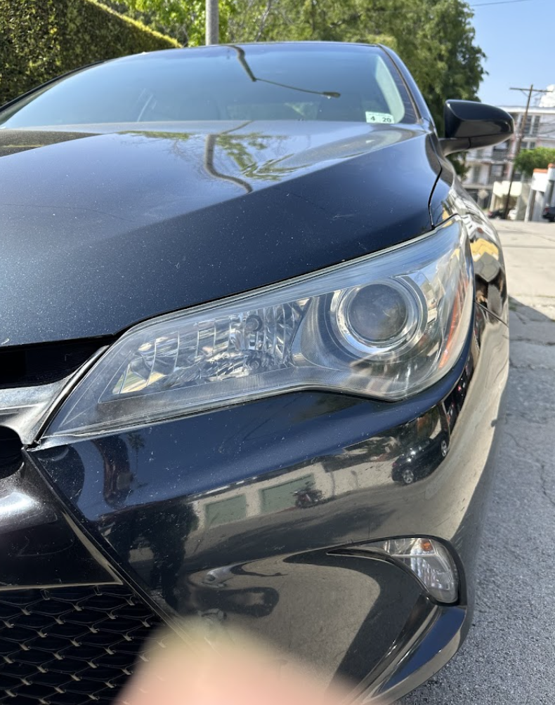 Black Toyota Camry front end with glossy corrected paint after machine polish