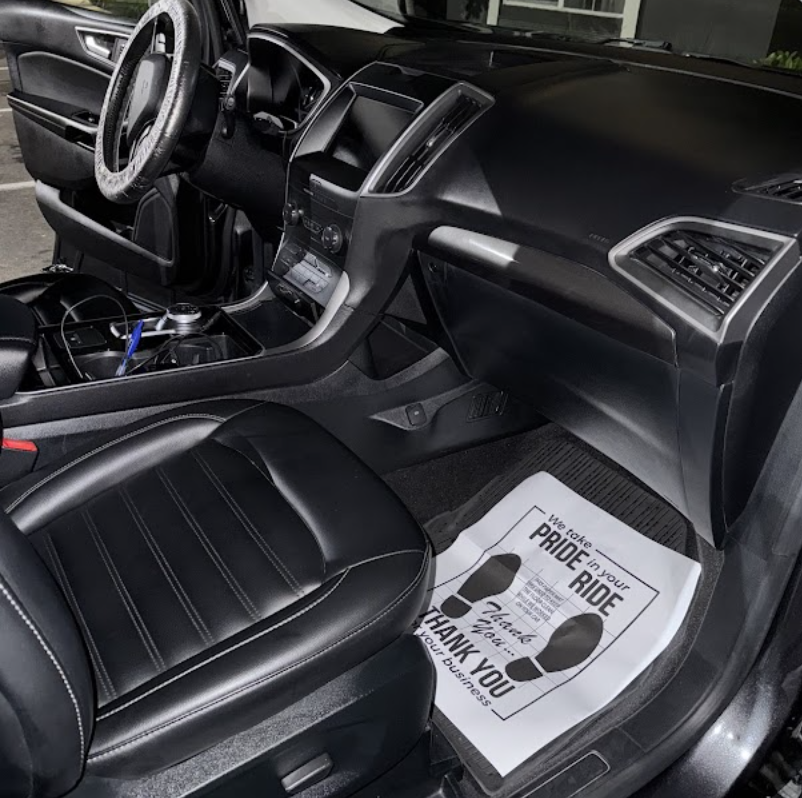 Detailed black leather Ford interior with cleaned dashboard and carpets