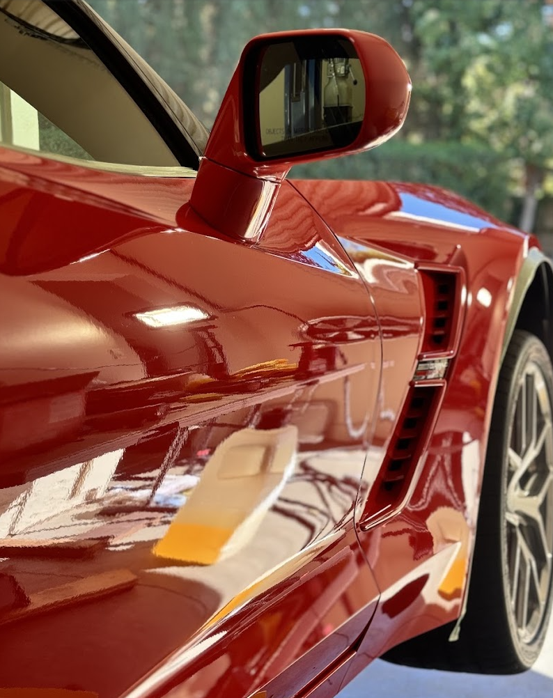 Glossy red Chevrolet Corvette paint after exterior car detailing and polishing